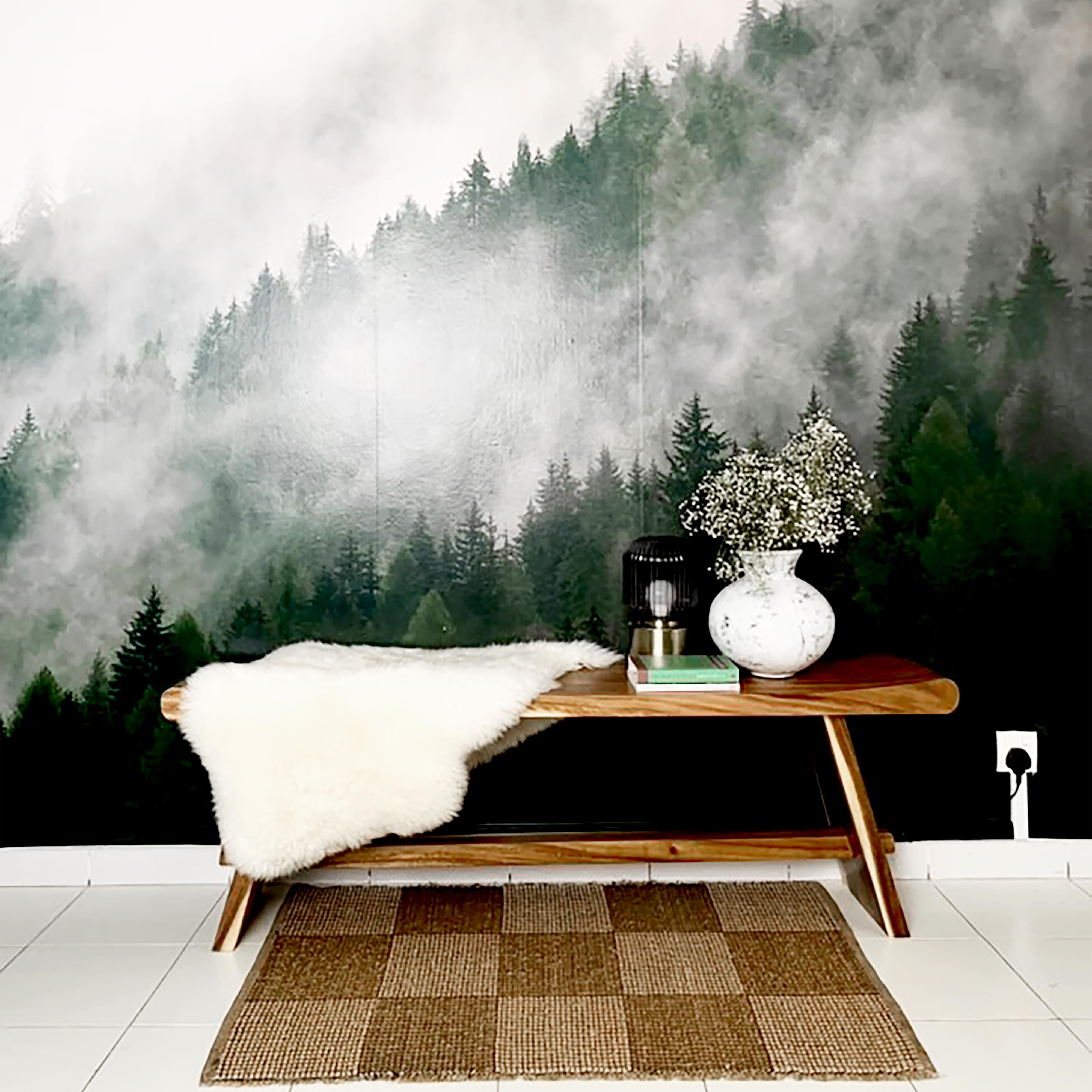 Cozy entryway with a rustic wood bench, fur throw, and checkered jute rug in front of a Misty Mountain wall mural featuring fog-covered evergreen trees – perfect for nature-inspired interior decor.